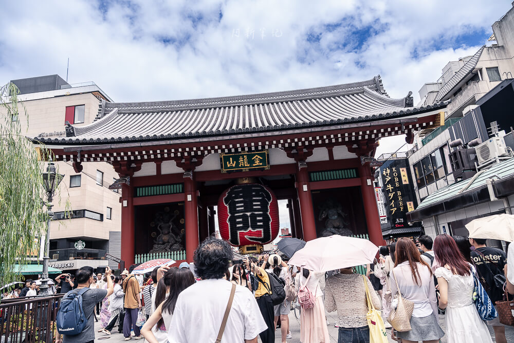 東京淺草寺仲見世商店街，石板路兩側紅色燈籠，遠方是雷門