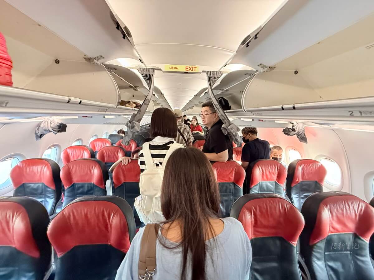 越捷航空客艙內紅黑色皮椅與正在入座的旅客